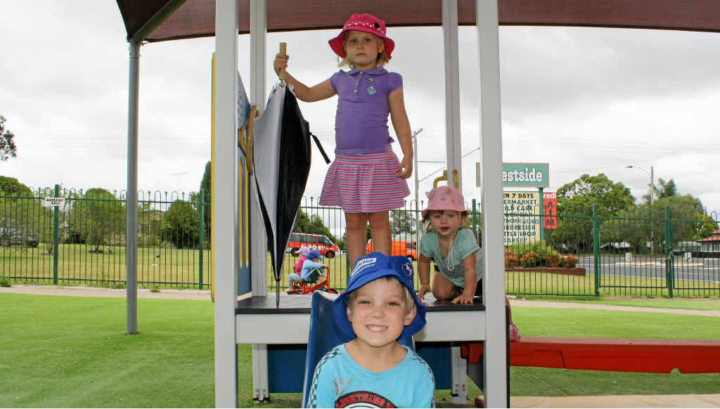 Goodstart Westside’s (back left) Heather Cox, 4, Emily O’Brien, 18 mths, and Harry Newton take cover from yesterday’s drizzly weather. Goodstart Westside’s (back left) Heather Cox, 4, Emily O’Brien, 18 mths, and Harry Newton take cover from yesterday’s drizzly weather.